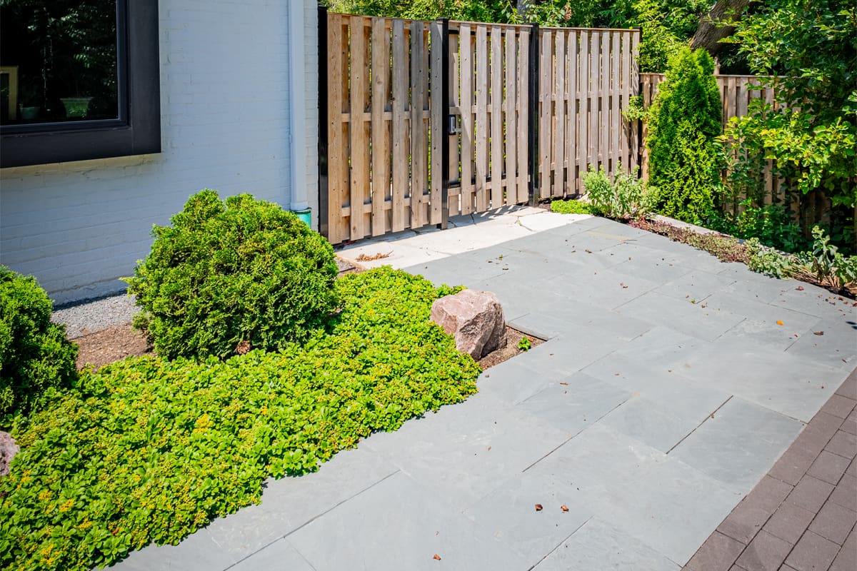 bluestone walkway with pavers leading to wooden fence