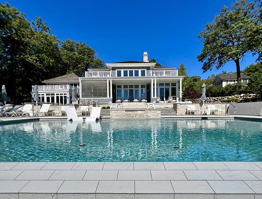 Completed lakeside pool and terrace with stone hardscape and seating overlooking the lake in Williams Bay, Wisconsin.