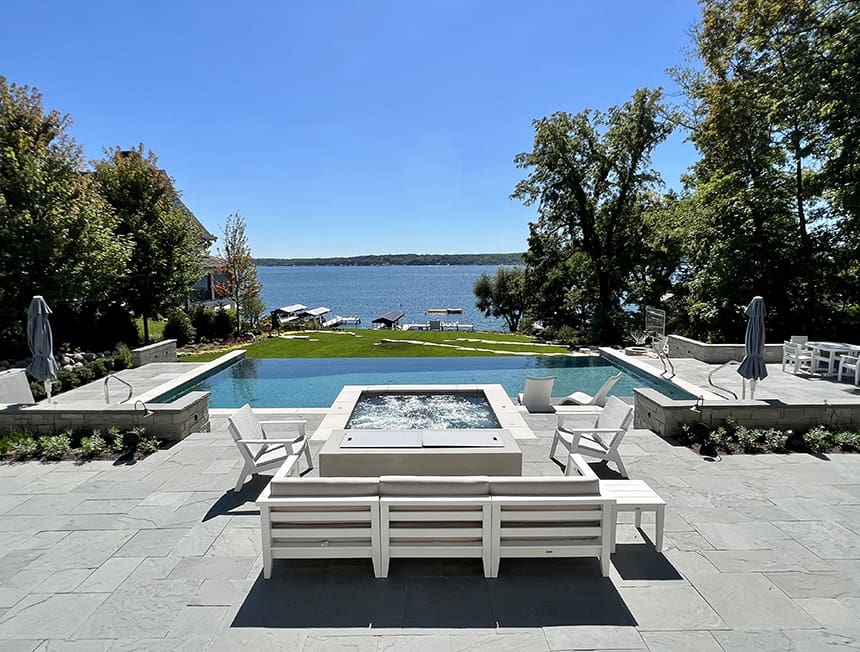 Completed lakeside spa and stone terrace with seating and lake views at a Williams Bay, Wisconsin property.